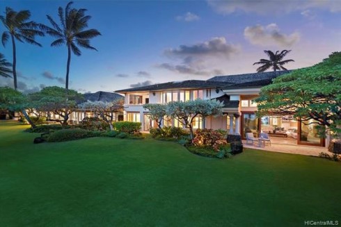 Beautiful home on Oahu Hawaii with green grass and palm trees